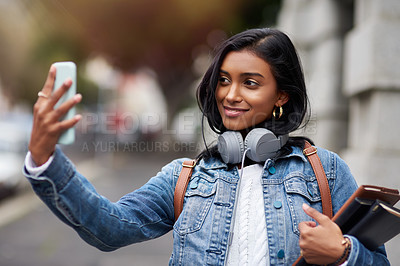 Buy stock photo Cropped shot of a young woman taking a selfie while out in the city