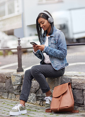 Buy stock photo Headphones, phone or Indian woman in city on social media for streaming song, music or radio on break. Student, mobile or girl listening to audio track on online subscription in urban town to relax