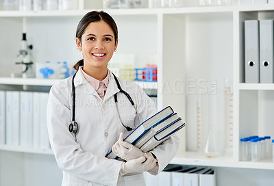 Buy stock photo Portrait of a young scientist holding a pile of books in a lab