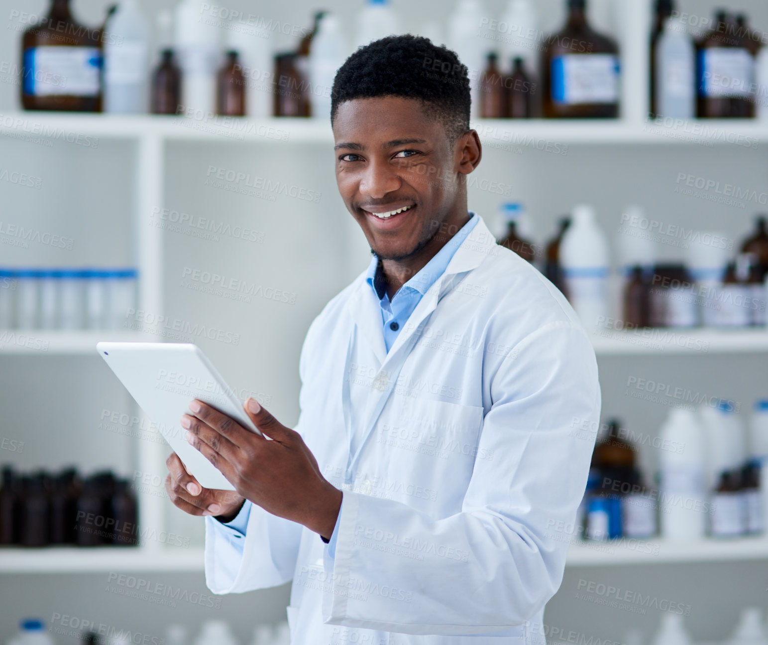 Buy stock photo Portrait of a cheerful young male scientist browsing on a digital tablet inside of a laboratory during the day