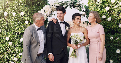 Buy stock photo Cropped shot of an affectionate young newlywed couple standing with their parents on their wedding day
