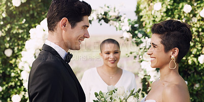 Buy stock photo Cropped shot of an affectionate young couple smiling at each other while saying their vows on their wedding day