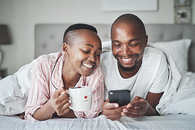 Buy stock photo Black couple in bed with phone, coffee and happiness with morning routine, social media or streaming online. Wifi, communication and technology with happy man and woman, relax at home together