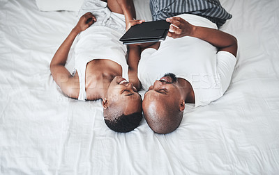 Buy stock photo Black couple, tablet and relax on bed with smile for entertainment, browsing or social media at home. Happy African American man and woman relaxing in bedroom on touchscreen for morning streaming
