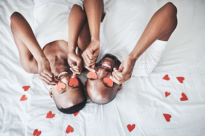Buy stock photo Heart, bed and overhead with a valentines day black couple lying in the bedroom of their home together. Love, face or emoji with a romantic man and woman in their house to relax from above