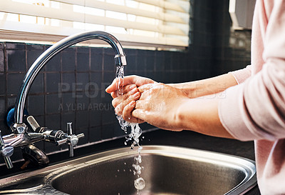 Buy stock photo Cropped shot of an unrecognizable woman washing her hand in the kitchen sink