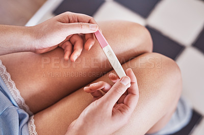 Buy stock photo Cropped shot of an unrecognizable woman taking a pregnancy test at home