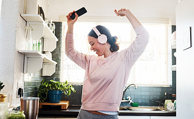 Buy stock photo Cropped shot of a young woman listening to music through her headphones