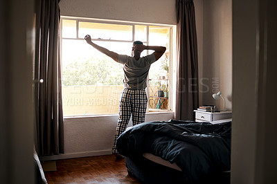 Buy stock photo Cropped shot of an unrecognizable man standing alone in his bedroom and stretching during a day off at home