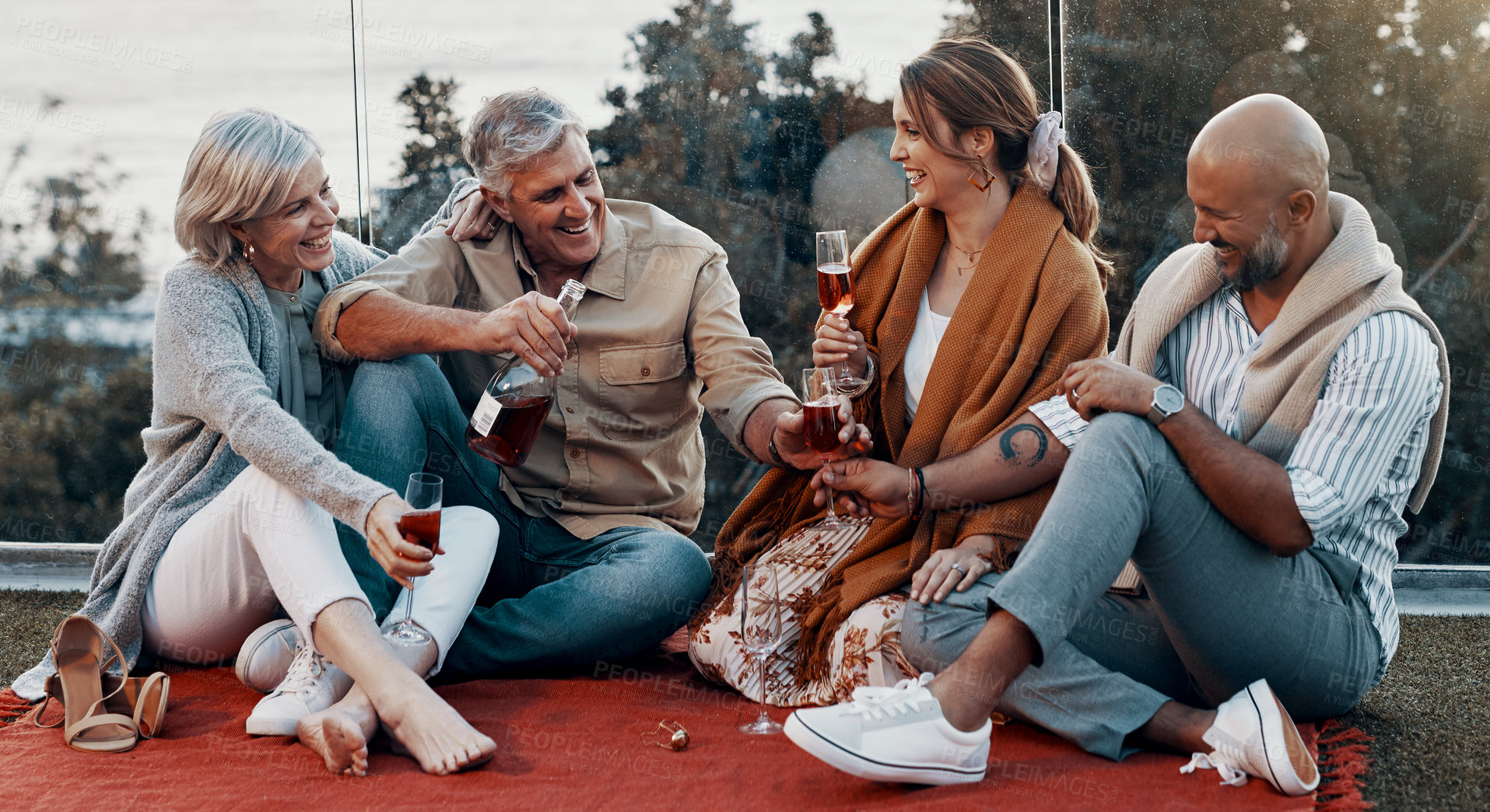 Buy stock photo Full length shot of an affectionate family having wine together while celebrating a new year outdoors