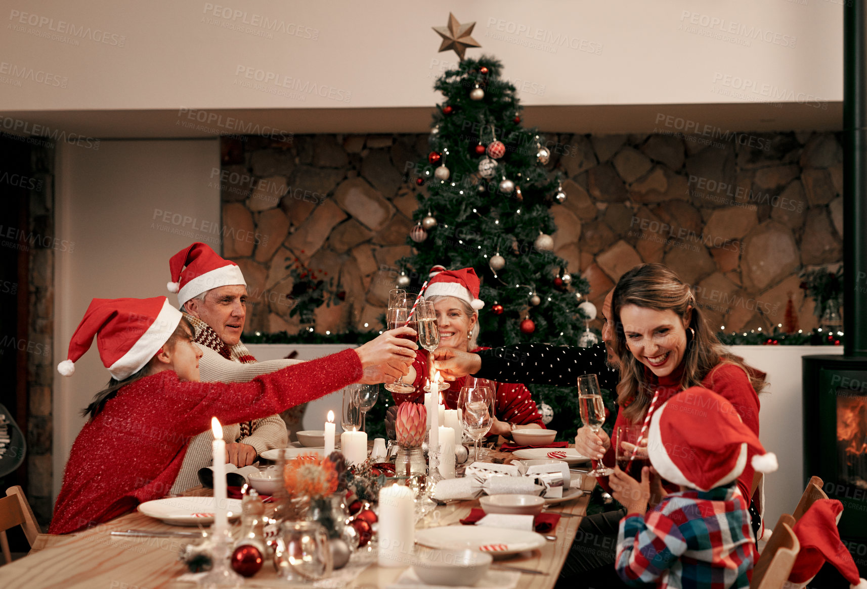 Buy stock photo Christmas, food and toast with family at table for celebration, festive and event. Wine, tree and party with parents and children on holiday with grandparents in dining room for dinner and cheers