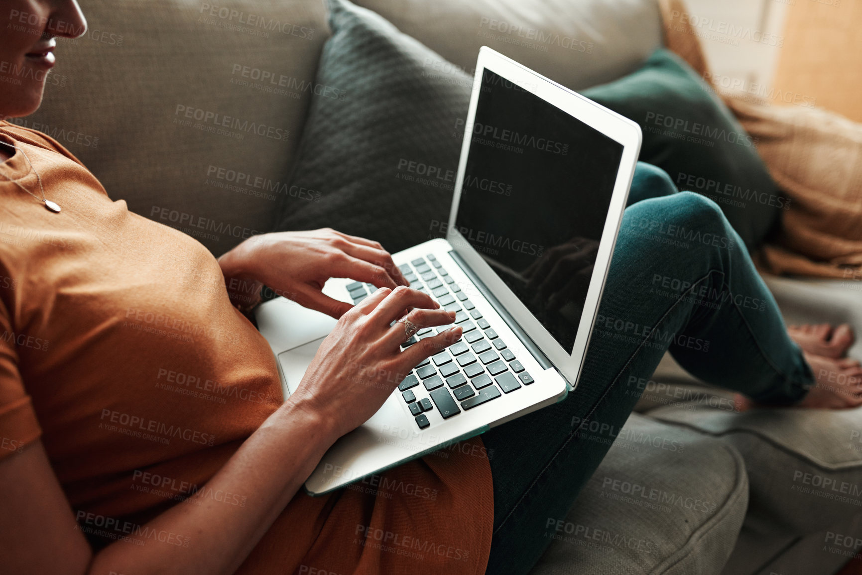 Buy stock photo Cropped shot of an unrecognizable woman using her laptop at home