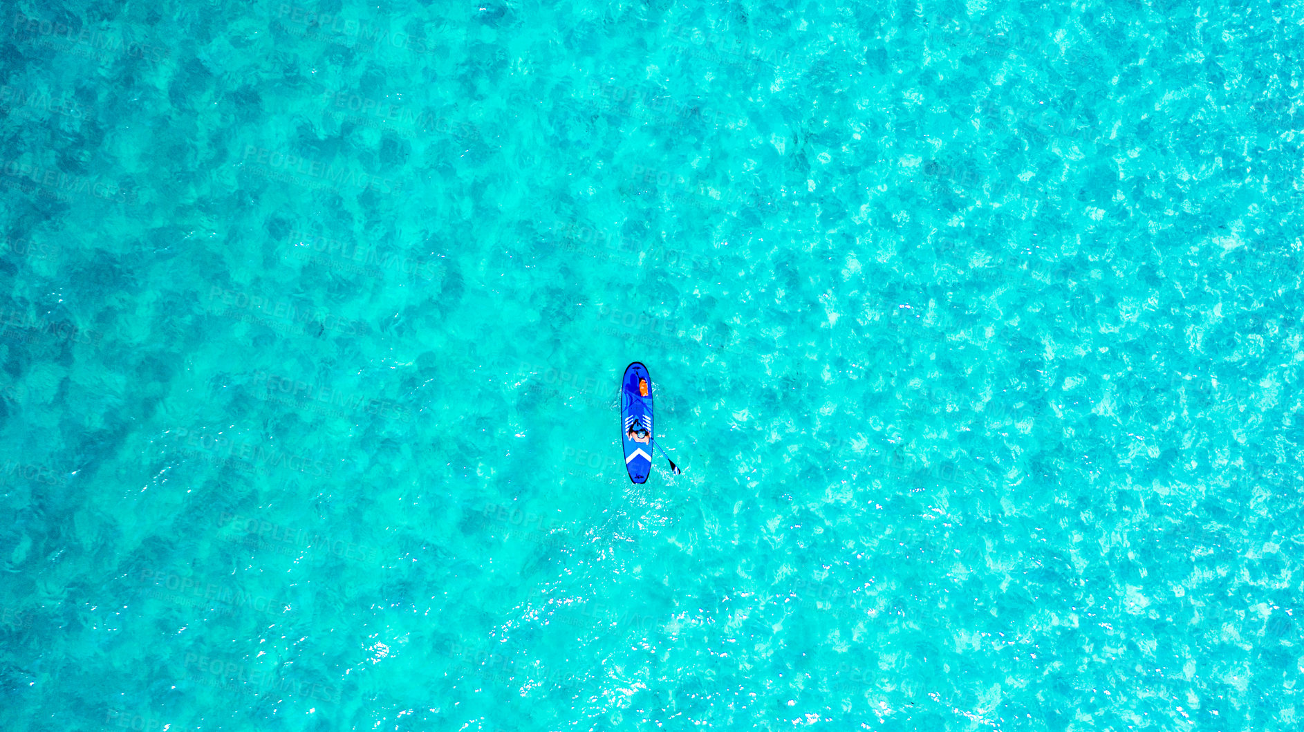 Buy stock photo High angle shot of a man paddle boarding across the sea