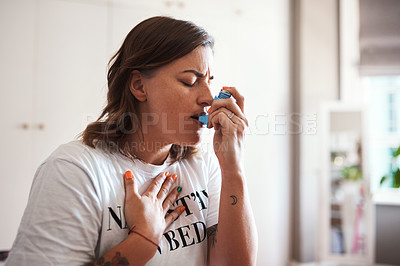 Buy stock photo Cropped shot of a beautiful young woman using her asthma inhaler