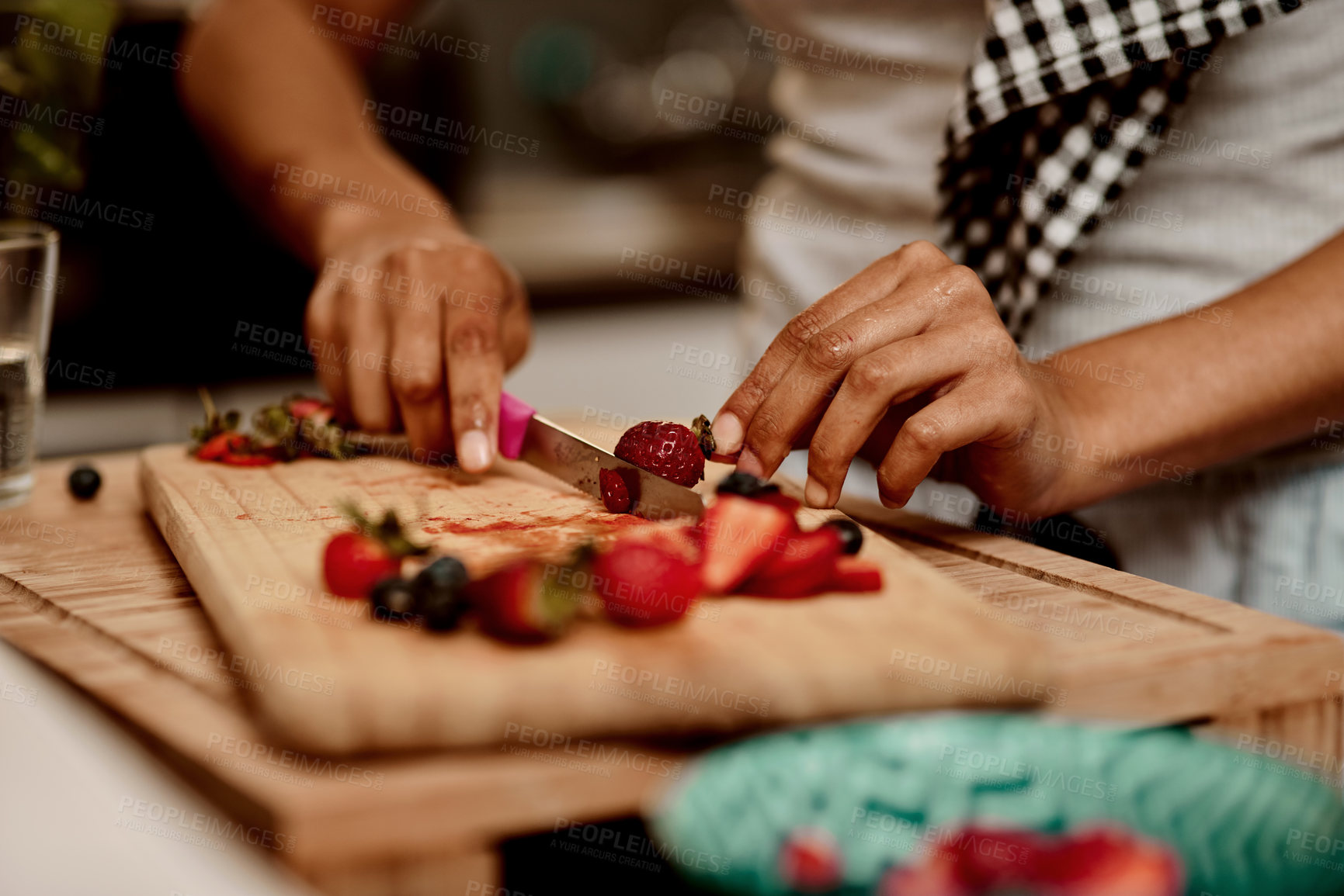 Buy stock photo Cropped shot of a woman making a healthy snack with strawberries at home
