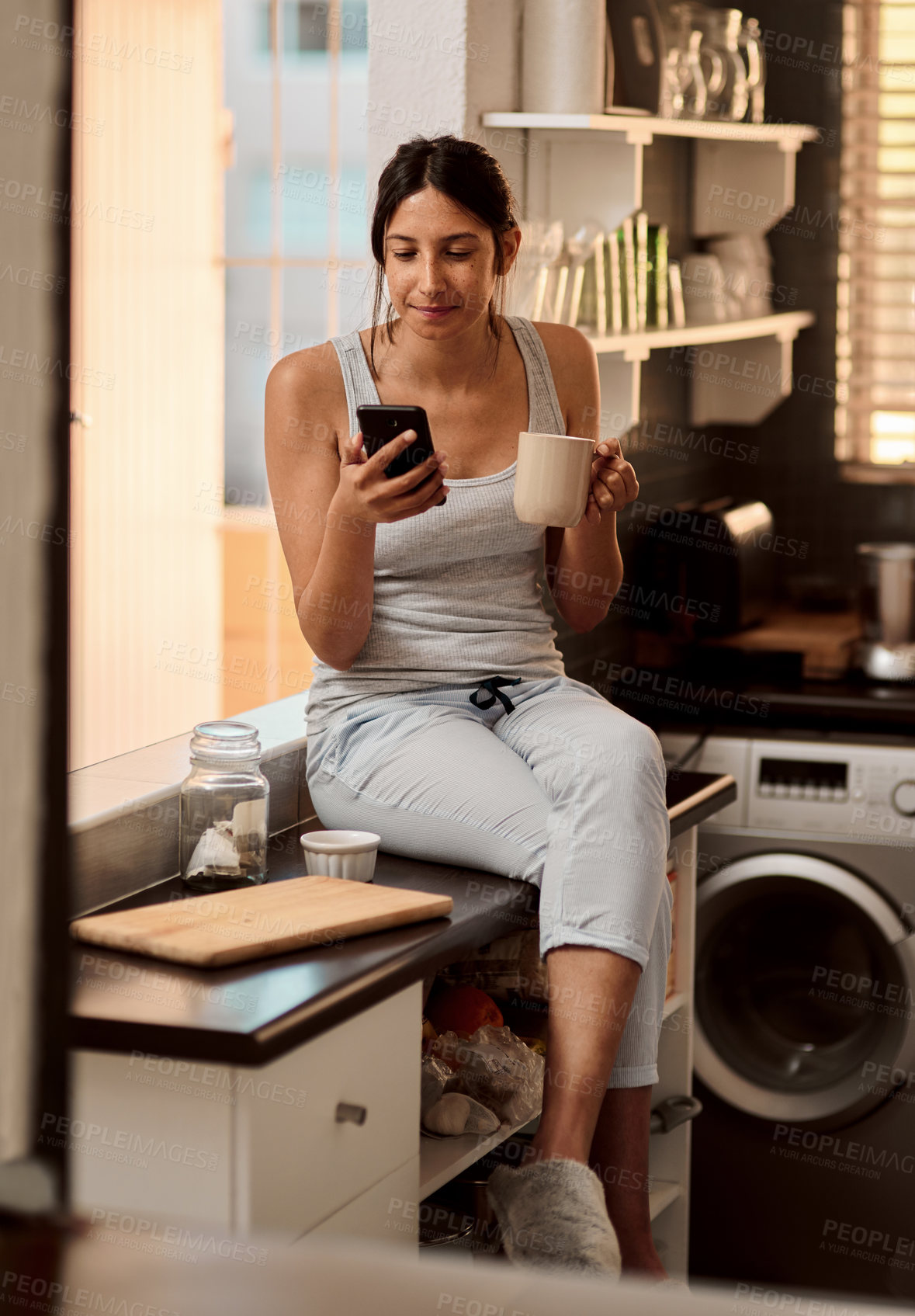 Buy stock photo Morning, coffee and woman with cellphone in home for social media, chat and text message with contact. House, girl and smartphone for networking, browsing and scrolling in kitchen with beverage