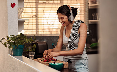 Buy stock photo Music headphones, morning and woman cooking breakfast of healthy strawberry food at home. Kitchen, headphone and happy female person making snack with fruits while listening to audio, sound and radio