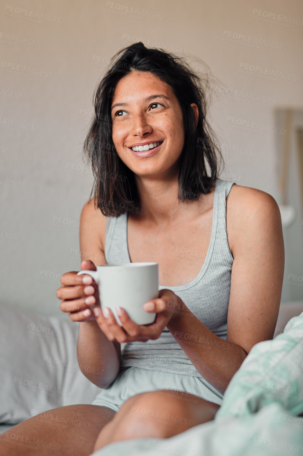 Buy stock photo Shot of a young woman enjoying a relaxing cup of coffee in bed at home