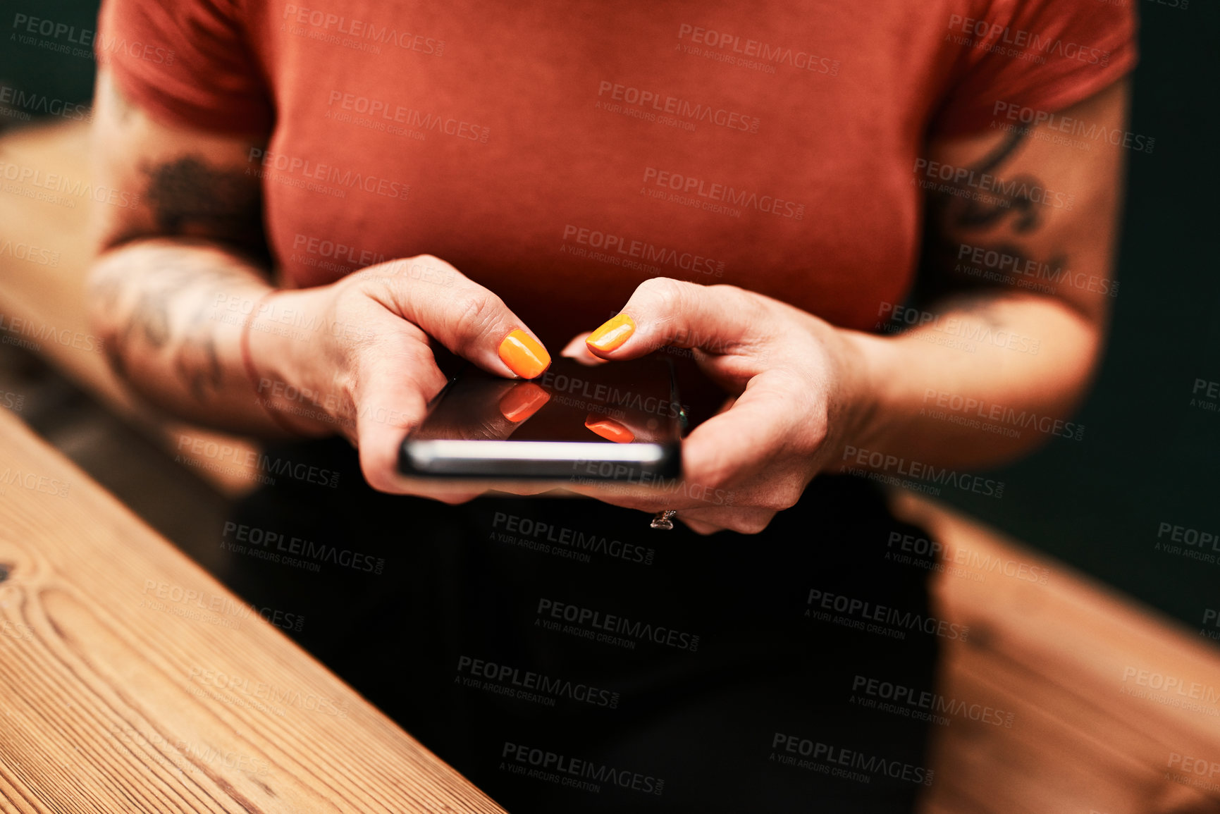 Buy stock photo Cropped shot of an unrecognizable businesswoman sitting alone at her desk and texting on her cellphone