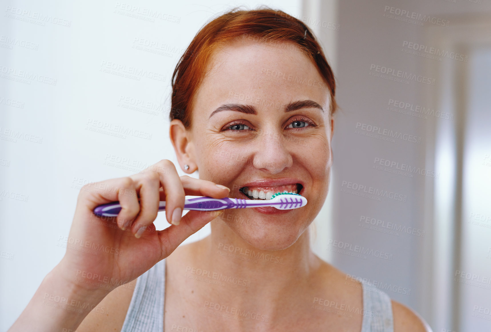 Buy stock photo Portrait of an attractive young woman brushing her teeth inside her bathroom at home