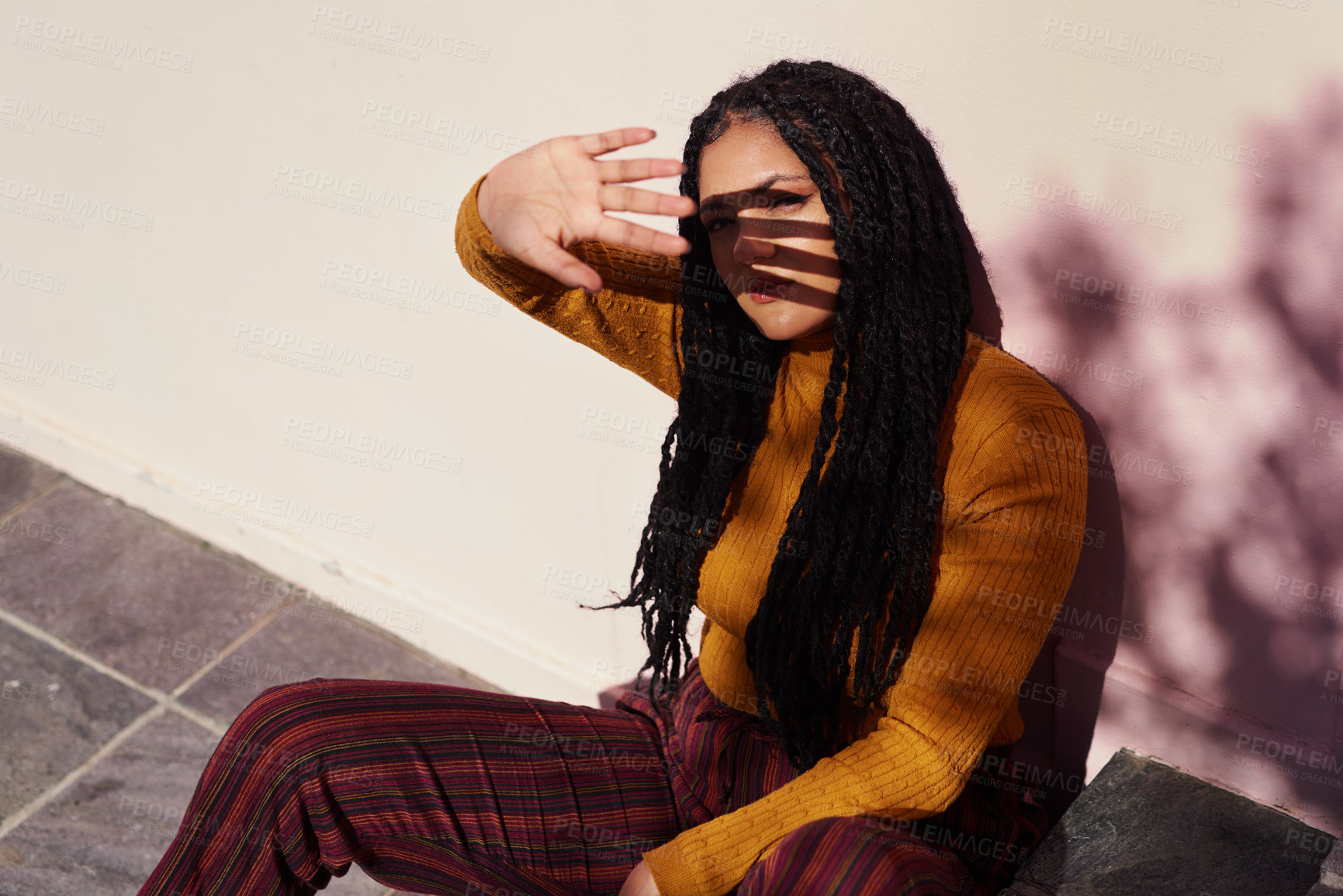 Buy stock photo Cover eyes, sunshine and woman at wall for portrait, urban style and vitamin d in city. Gen z girl, hand up and sunlight on steps for break, rest and relaxation with dreadlocks or streetwear