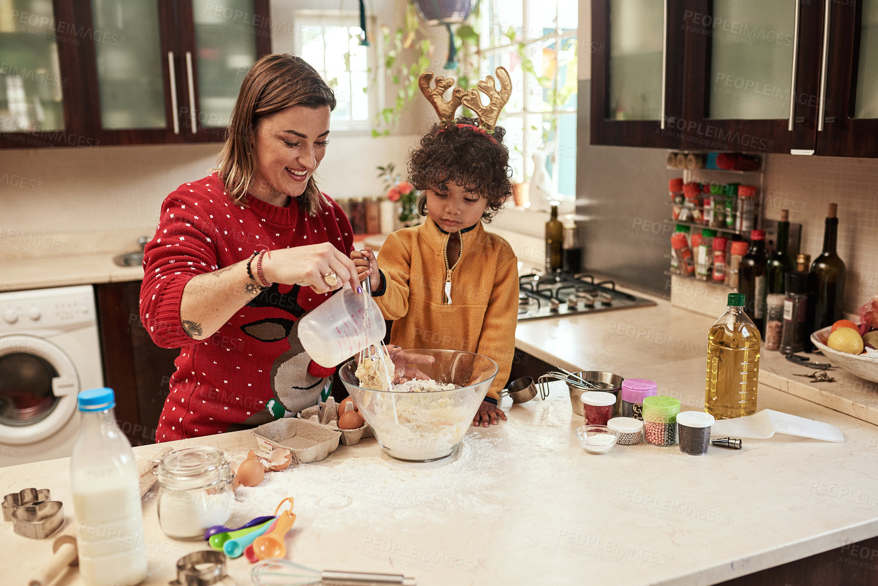 Buy stock photo Cropped shot of a cheerful young woman and her son baking cookies together in the kitchen during christmas time at home