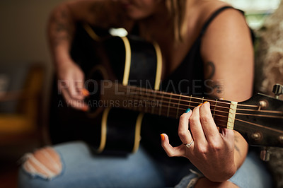 Buy stock photo Cropped shot of an unrecognizable woman playing a guitar at home
