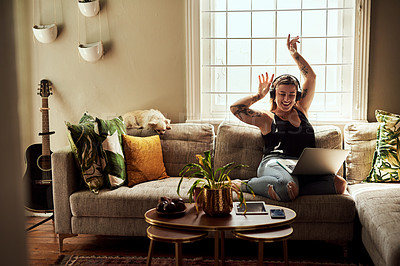Buy stock photo Music, headphones and woman on sofa and laptop dancing, happy energy and mental health in boho apartment. Young person listening to audio technology, electronics and computer in living room or home
