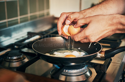 Buy stock photo Cropped shot of an unrecognizable man frying eggs in his kitchen at home