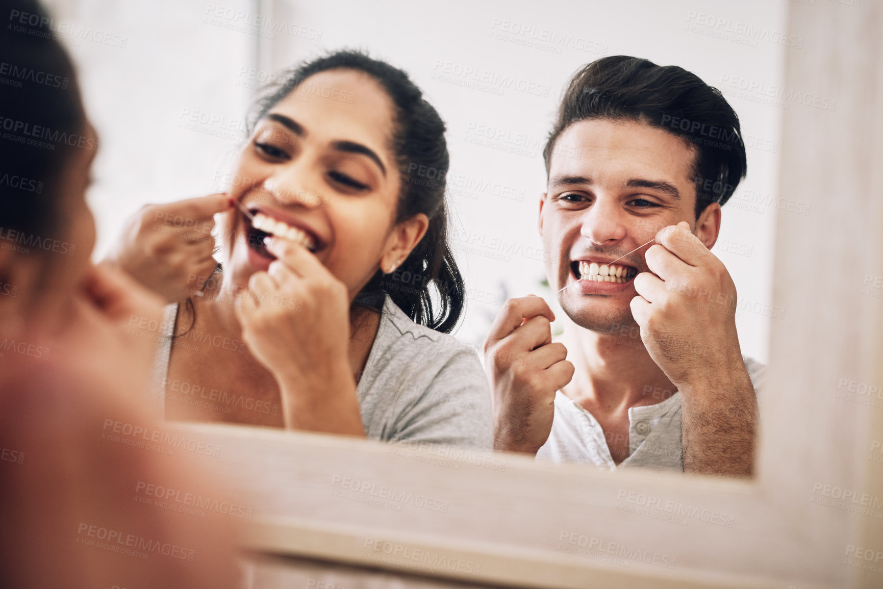 Buy stock photo Cropped shot of a young couple flossing their teeth together