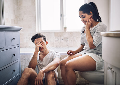 Buy stock photo Shot of a young couple looking upset after taking a home pregnancy test