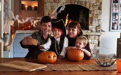 Buy stock photo Shot of an adorable young family taking selfies together with a cellphone on halloween at home