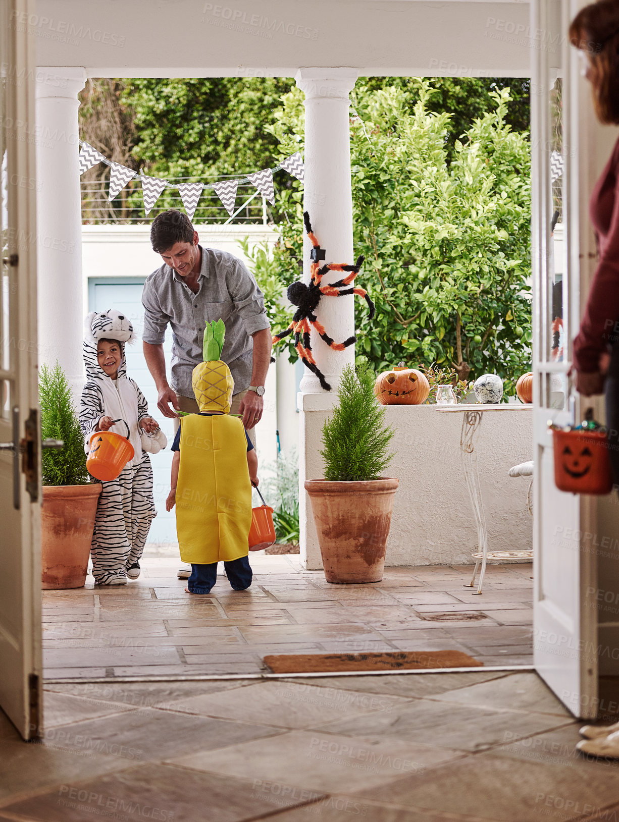 Buy stock photo Full length shot of two adorable little boys celebrating halloween with their parents at home
