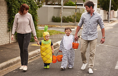Buy stock photo Full length shot of an adorable young family trick or treating together in the neighborhood on halloween