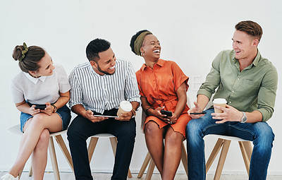 Buy stock photo Cropped shot of a diverse group of businesspeople sitting against a gray background together and using technology in the office