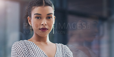 Buy stock photo Cropped portrait of an attractive young businesswoman looking serious while standing in a modern office