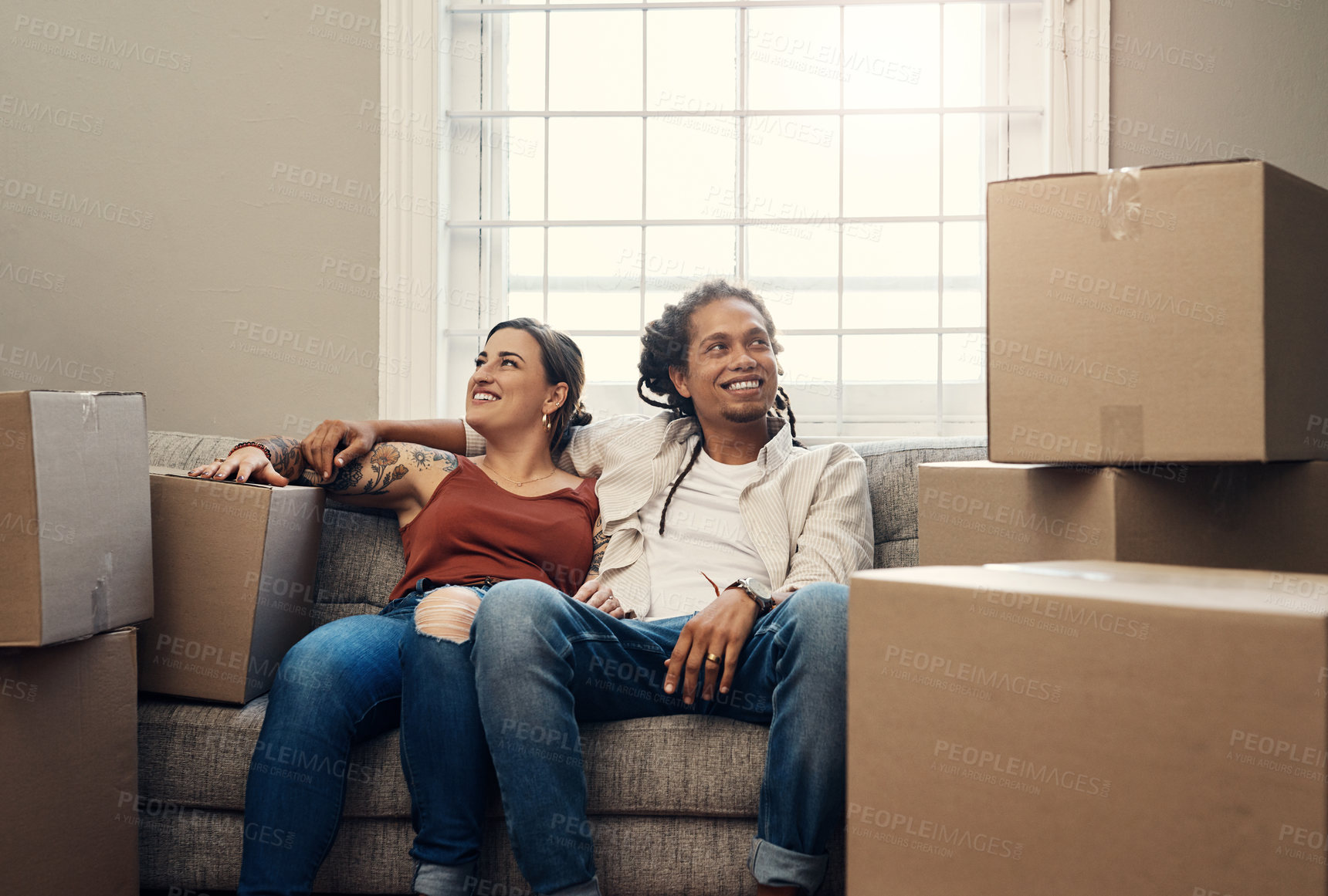 Buy stock photo Moving, interracial couple and homeowner on sofa for mortgage, real estate or boxes. Living room, investment and happy woman with man for residence, property rent or relocation in new apartment