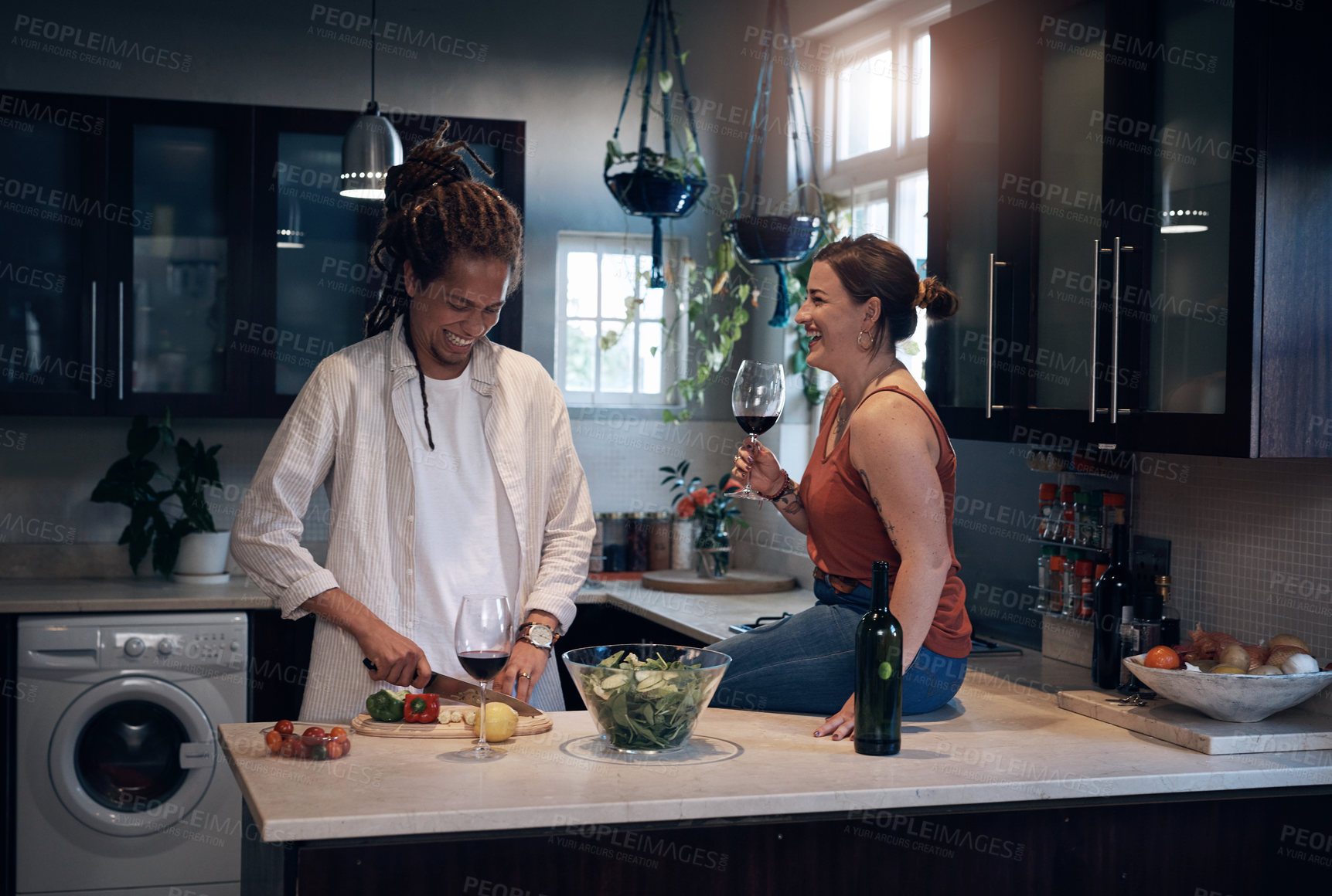 Buy stock photo Shot of a young couple bonding in the kitchen while preparing a salad