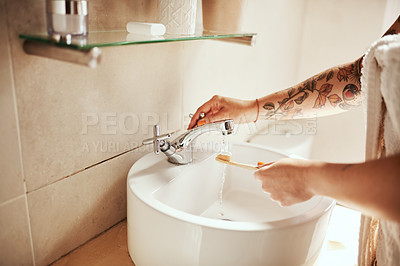Buy stock photo Cropped shot of a woman brushing her teeth in the bathroom at home