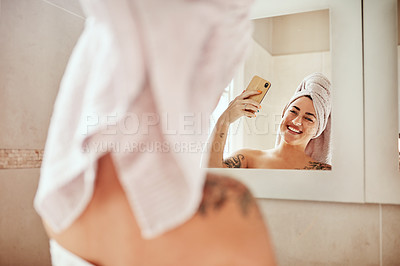 Buy stock photo Shot of a young woman taking a selfie while going through her morning beauty routine