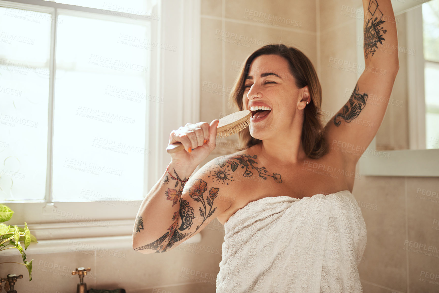 Buy stock photo Woman, happy and brush in bathroom for singing, morning routine and excited for self care with towel. Female person, smile and dance in home for personal hygiene, grooming and weekend with tattoo