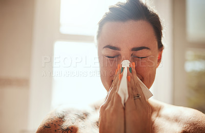 Buy stock photo Shot of an attractive young woman blowing her nose during her morning beauty routine at home