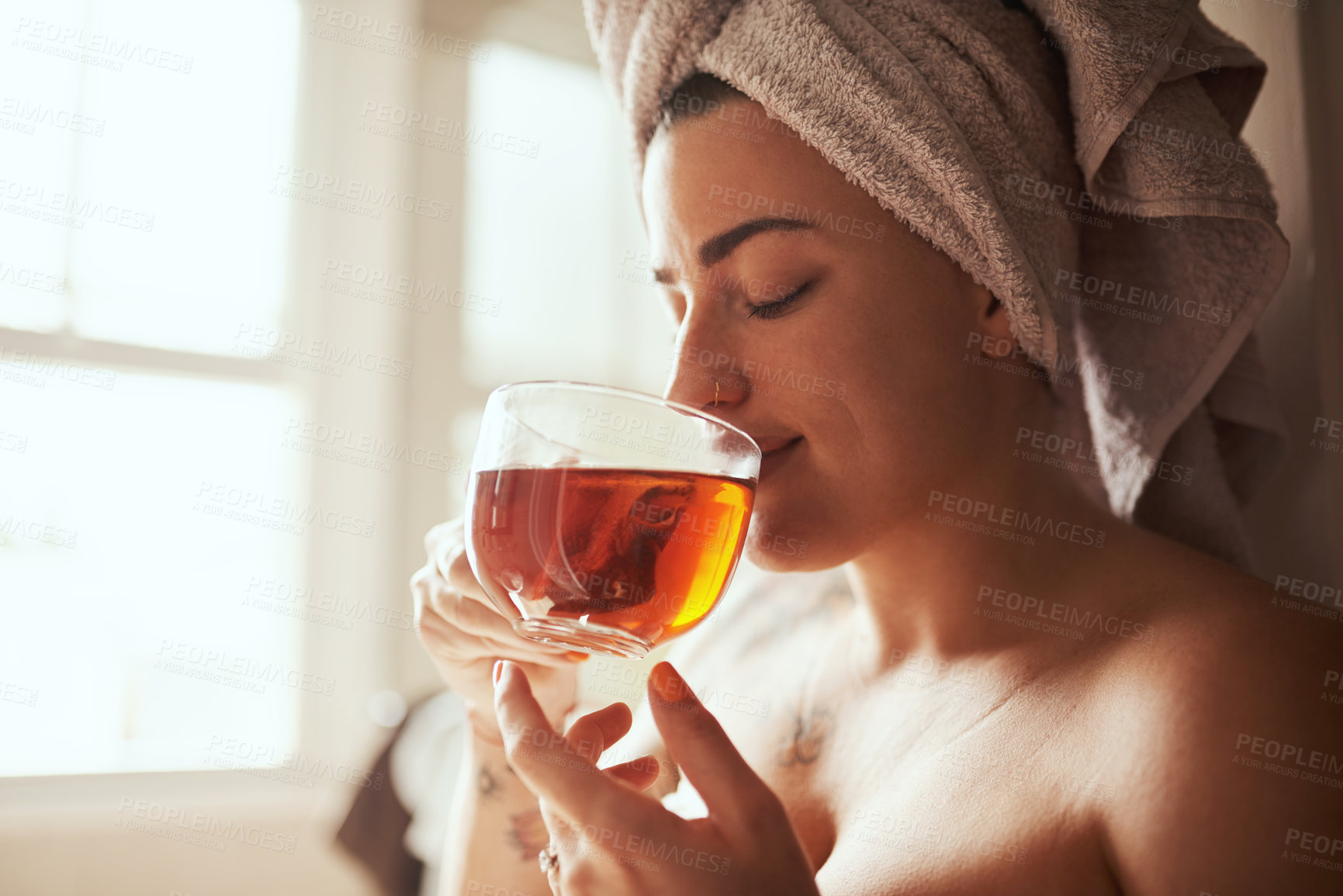 Buy stock photo Woman, relax and drinking with tea for morning routine, hygiene or cleanse in bathroom at home spa. Young, female person or window with beverage for calm breakfast, detox or peaceful day at house