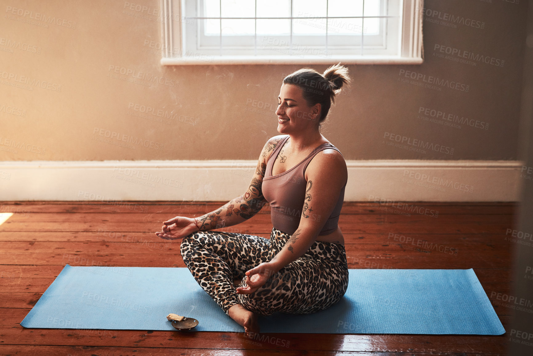 Buy stock photo Woman, home  and smile for meditation with sage for peace, calm and mental health or mindfulness. Female person, holistic and spiritual with zen as activity for wellbeing, self care with incense