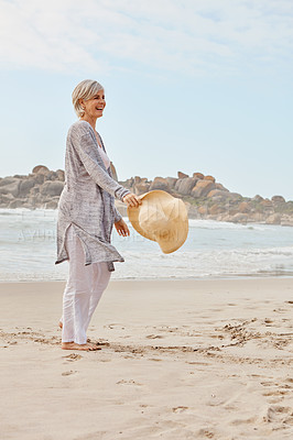 Buy stock photo Full length shot of an attractive middle age woman walking along the beach