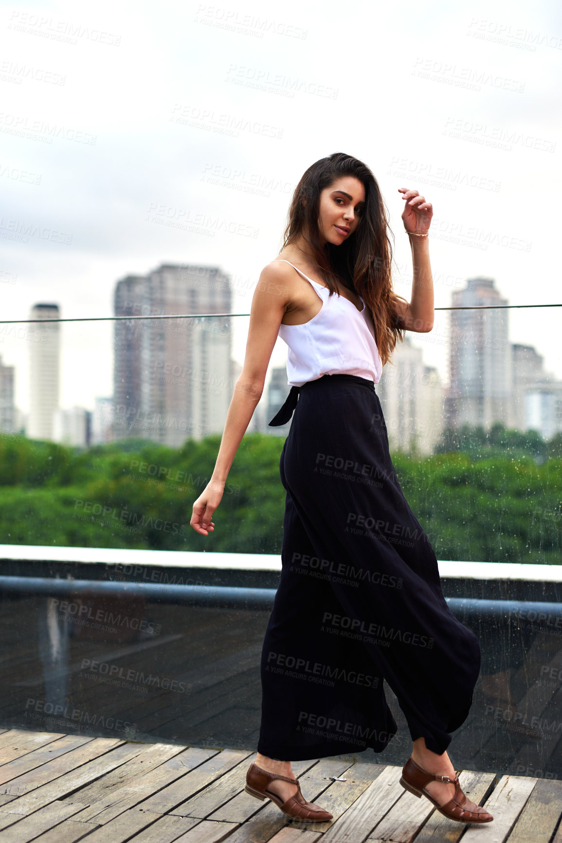 Buy stock photo Cropped portrait of an attractive young woman walking along a balcony in the city during the day