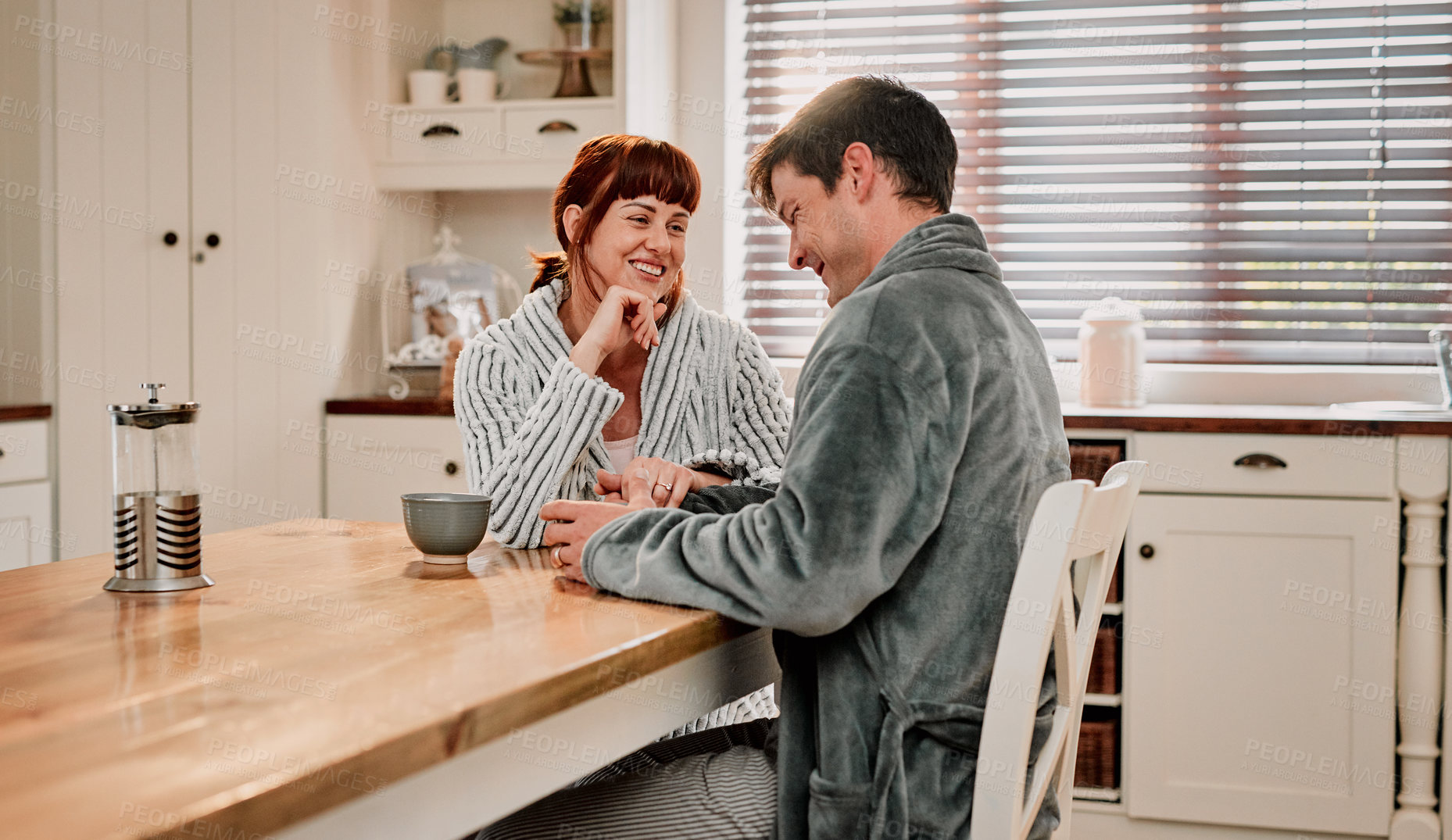 Buy stock photo Cropped shot of a couple having their morning coffee in their kitchen