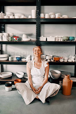 Buy stock photo Full length portrait of an attractive mature woman sitting contently on the floor alone in her pottery workshop