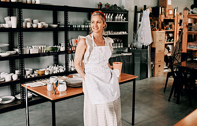 Buy stock photo Cropped shot of an attractive mature woman standing alone in her pottery workshop during the day