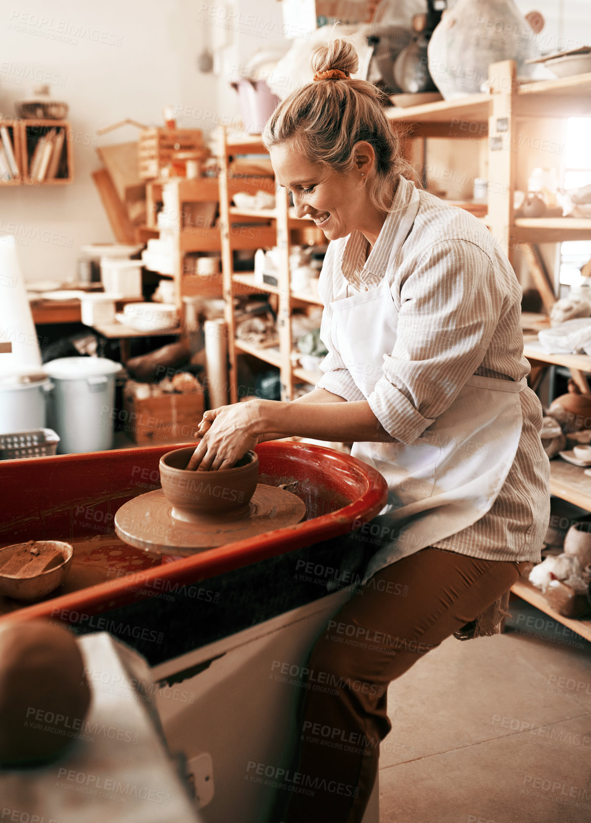 Buy stock photo Shot of a female artisan working in her pottery workshop